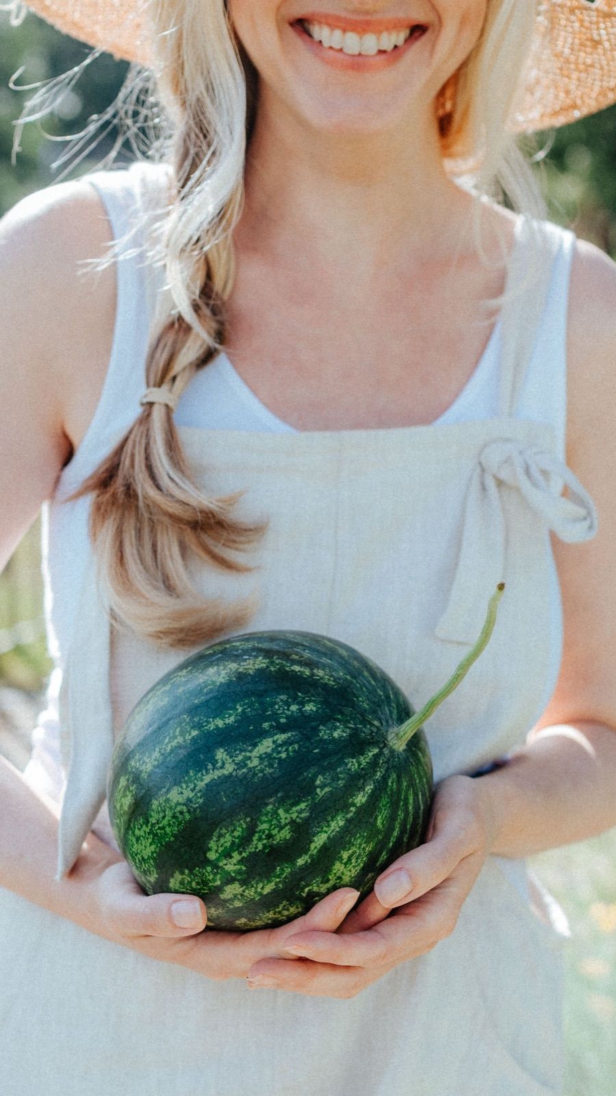 Frau hält eine Wassermelone aus dem eigenen Garten
